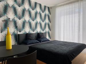布尔诺Business Apartments的一间卧室配有一张床、一张桌子和一面墙