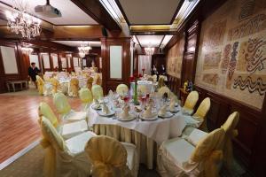 罗曼Hotel Roman by Dumbrava Business Resort的一间长餐厅,配有白色的桌子和椅子