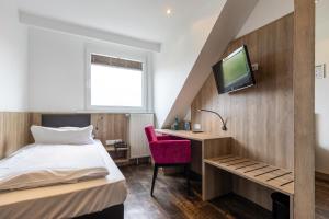 杜塞尔多夫Trip Inn Hotel Esplanade的一间卧室配有一张床、一张书桌和一台电视。