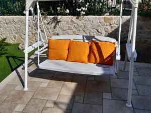 鲁沃迪普利亚La Palma的庭院内白色秋千和橙色枕头