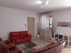 鲁沃迪普利亚La Palma的客厅配有红色的沙发和椅子