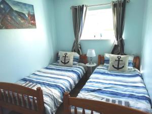布德Chalet 26 Widemouth Bay的带窗户的客房内设有两张单人床。