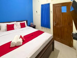 诗都阿佐RedDoorz Syariah @ Pahlawan Sidoarjo的一间卧室配有一张红色和蓝色的大床