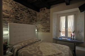 奥尔塔圣朱利奥卢坎达迪奥尔塔宾馆的一间卧室设有一张床和砖墙