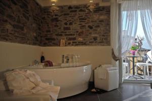奥尔塔圣朱利奥卢坎达迪奥尔塔宾馆的石墙客房内的浴缸