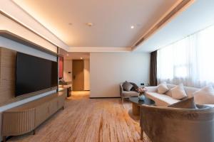 深圳深圳东门中泰来大酒店的客厅配有大屏幕平面电视