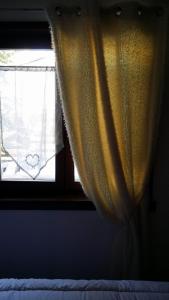 蒙热内夫尔南部公寓的卧室内带黄色窗帘的窗户