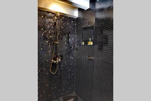 里昂Le Boudoir的黑色浴室设有黑色瓷砖淋浴