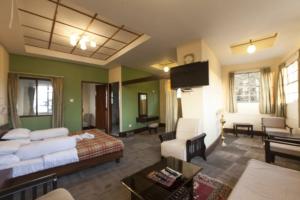 大吉岭Darjeeling Tourist Lodge的酒店客房设有床和客厅。