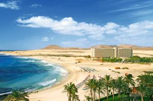 科拉雷侯Hotel Riu Oliva Beach Resort - All Inclusive的棕榈树海滩,酒店和海洋