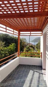 瓦西Aletri & Orgoma的户外阳台设有木制凉亭,享有山景