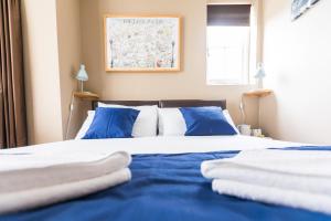 伦敦Belgravia Rooms Hotel的一张带蓝色和白色床单及蓝色枕头的床