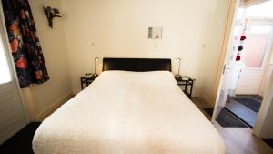 登海尔德Rumah Senang的一间卧室配有一张带白色床罩的床