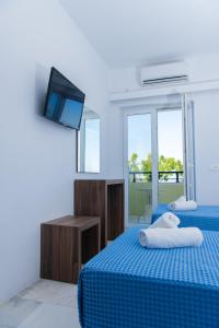 费拉圣托里尼酒店的蓝色的客房配有两张床和电视