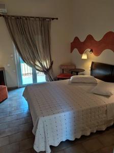 尼基亚娜Sunrise Hotel Nikiana Lefkada的一间卧室设有一张大床和一个窗户。