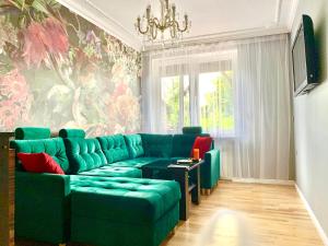 克拉科夫Cracow. Villa Cherubin Garden的客厅配有绿色沙发和吊灯。