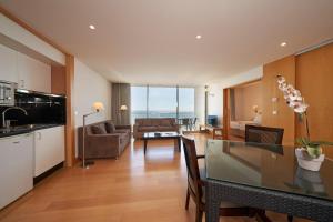 丰沙尔金色公馆酒店的厨房以及带桌子和沙发的客厅。