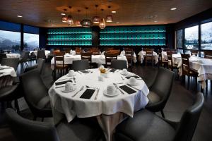 福米加尔HG阿尔拓阿拉贡酒店的一间配备有白色桌椅的用餐室