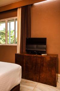 塔里法特里斯马里斯休闲酒店的一间卧室配有一张床和一张桌子上的电视