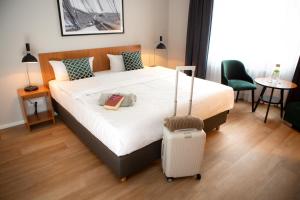 基尔图姆凯尔康福特酒店的酒店客房,带一张床和行李箱