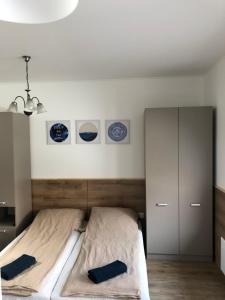 米什科尔茨Avas Apartman的卧室配有一张墙上的三盘床