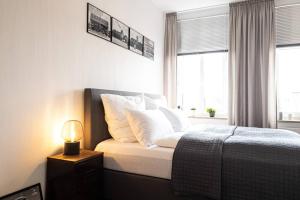 莱比锡Luxus-Apartment in Leipzig mit Privat-Parkplatz的一间卧室配有带白色枕头和灯的床