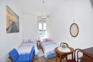 希贝尼克Apartmani Rina的客房设有两张床、一张桌子和镜子