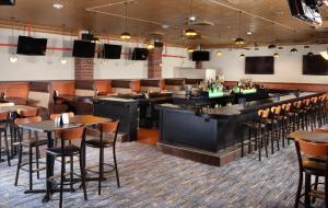 绿湾绿湾凯悦酒店的一间带桌椅的餐厅和一间酒吧