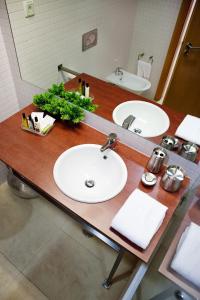 波尔蒂芒维斯塔码头公寓酒店的浴室柜台设有两个盥洗盆和镜子