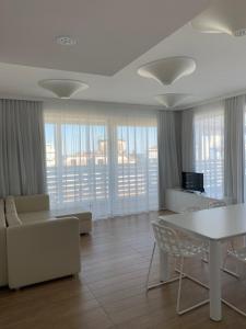 卡奥莱Marina Verde Resort Official的客厅配有白色的桌子和椅子