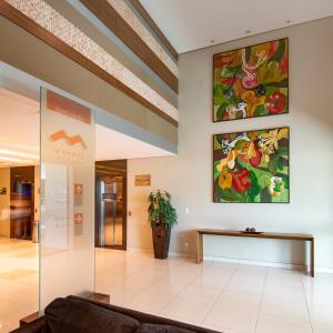 马瑙斯维尔弗斯机场快线酒店的大堂配有沙发和墙上的绘画作品