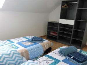 普勒尔蒂Gite es Omnes的一间卧室设有两张床和书架