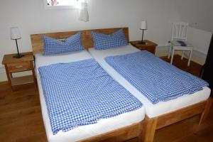 RüthenHaus Buuck - Herberge的一间卧室配有两张带蓝白色枕头的床