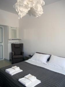Monteleone Rocca DoriaBrancadoria B&B的一间卧室配有一张带椅子和吊灯的床。