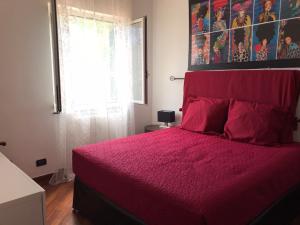 阿伦扎诺Chez Christine 2的一间卧室配有一张带红色床罩的床和窗户