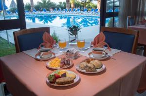 韦拉斯Hotel Sao Jorge Garden的餐桌,带食物盘和橙汁杯