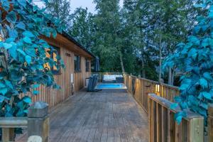 奥特本Settlers Lodge的一个带游泳池和房子的木甲板