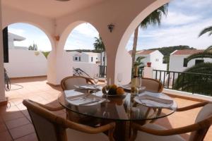 桑帕克Apartamento Albatros-Son Parc Menorca的阳台的用餐室配有桌椅