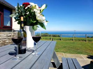 卡迪根Byre Cottages & Log Cabin的一张桌子,上面放着两杯葡萄酒和花瓶