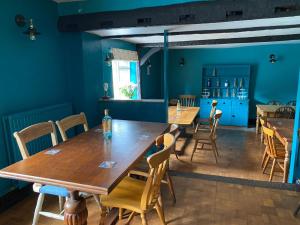 沙夫茨伯里The Benett Arms的一间拥有蓝色墙壁和木桌及椅子的用餐室