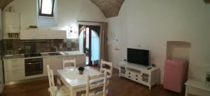斯佩洛Borgo San Sisto Apartment的厨房配有桌子和台面上的电视