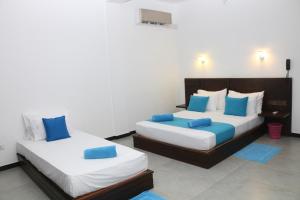 坦加拉Seafood Restaurant and Motel的蓝色和白色的客房内的两张床