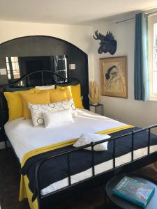 斯特拉斯堡奎壹17号旅馆的一间卧室配有一张带黄色枕头的大型黑色床。
