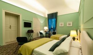 米拉佐I PRINCIPI di CASADOR HOUSE HOTEL的一间卧室设有两张带绿色墙壁的床