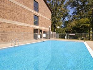 Kennett肯尼特速8汽车旅馆的一座砖砌建筑旁边的大型蓝色游泳池