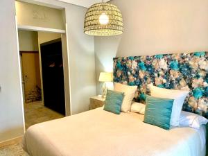 梅里达Hotel Spa Adealba的一间卧室配有一张大床和花卉床头板