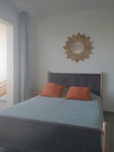 勒格罗-迪鲁瓦ESCALE AU GRAU DU ROI的一张蓝色的床,配有两个橙色枕头和镜子
