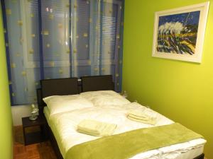 萨格勒布萨格勒布尊贵公寓的一张小床,位于带绿色墙壁的房间里