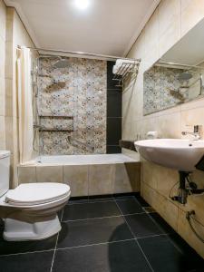 马尼拉Bay Area Suites Manila的浴室配有卫生间、盥洗盆和浴缸。