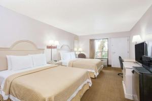 纳瓦拉Days Inn & Suites by Wyndham Navarre - near Beaches Hurlburt的酒店客房设有两张床和一台平面电视。